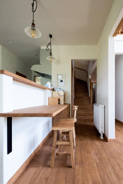 対面式キッチンのカウンターの奥に2階への階段を設置。キッチンで家事をしながら、子どもの動きを感じられる