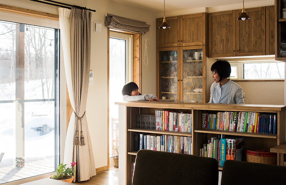対面式キッチンのカウンターは高さを抑え、リビング側に本棚を造作。家事をしながら、親子の会話も楽しめる