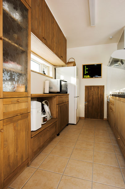 キッチンの食器棚には、Nさん所有のレトロな型押しガラスをはめ込んで。正面の扉は、階段下を利用した食品庫