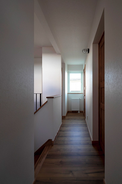 採光窓やリビングから伝わる光が美しい陰影をつくり出す2階階段ホール。2階には家族の個室とトイレ、書斎がある
