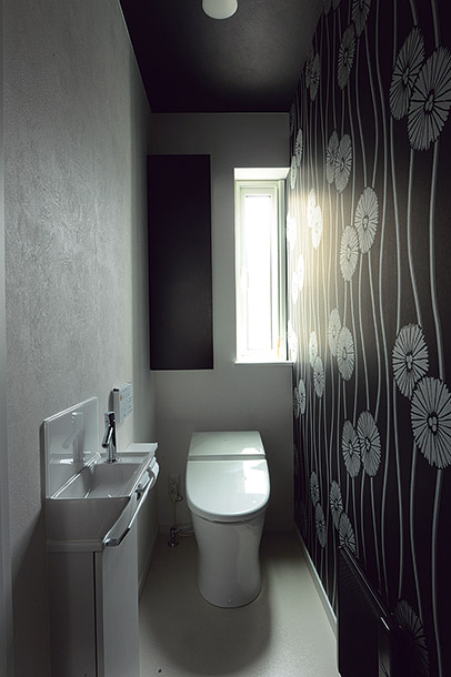 白を生かしたLDKに対し、主寝室やトイレは落ち着きのあるダークトーンを基調に。トイレには大胆な花柄の壁紙を採用し、個性的な空間に仕上げた