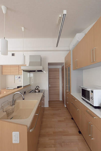 TOCLASのシステムを採用した対面式キッチンと背面収納。キッチン奥の引き戸を開けると、ユーティリティ